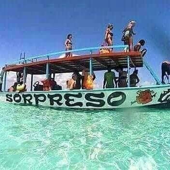 Fresh seafood grilling on the beach with a tour boat anchored in the shallows behind